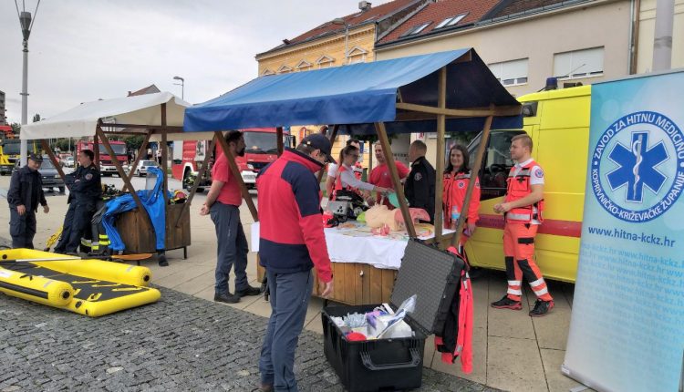 Slika prolaznika kako gledaju štand HMP
